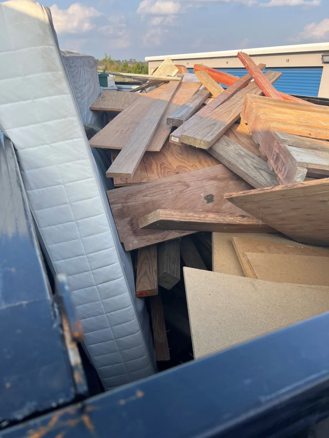 Storage unit filled with wood pallets, mattresses and junk before Clearout Junk removal in New Caney TX