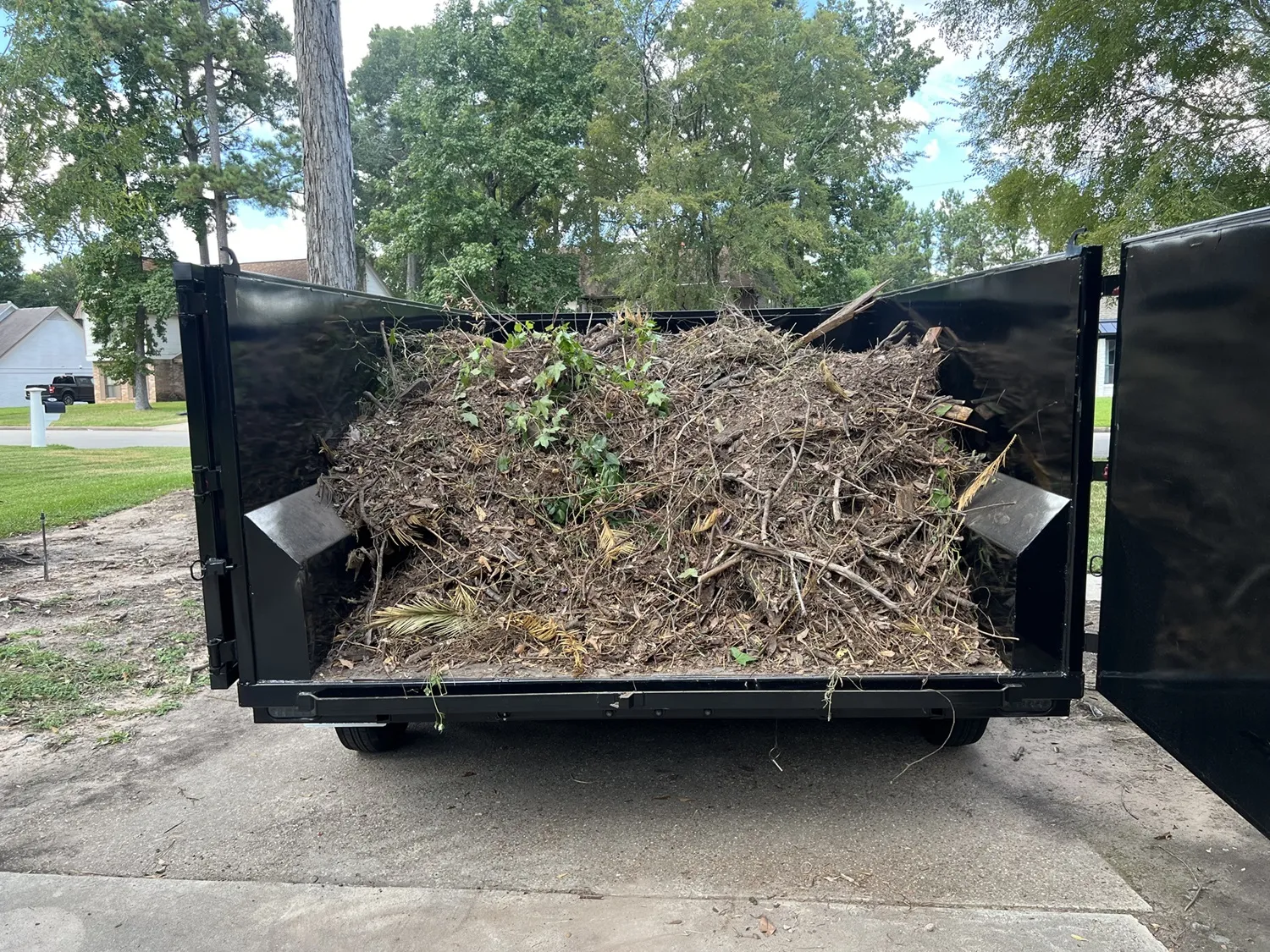 Overgrown shrubs and yard debris before removal by Clearout Junk