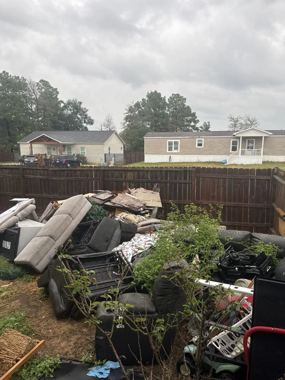 Backyard junk pile of couches and scrap wood before removal in Conroe TX 77303