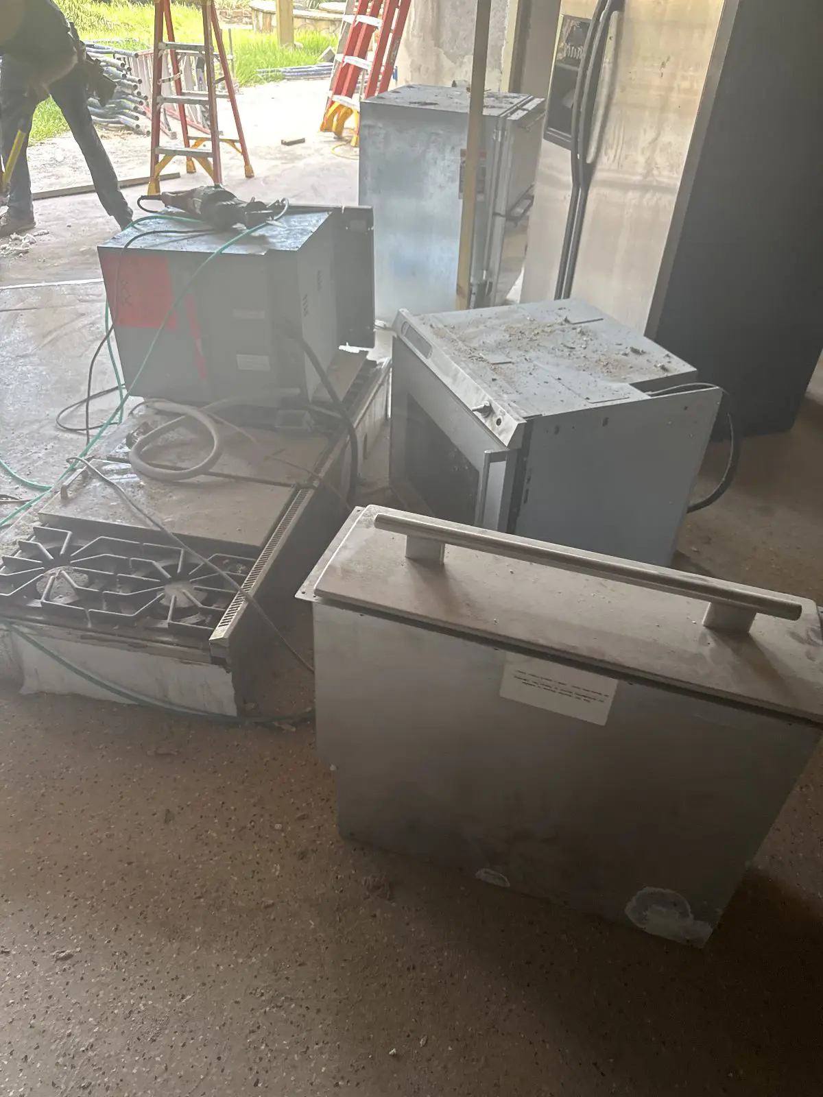 Wall ovens cooktop and dishwasher staged in a garage for haul-off in The Woodlands TX
