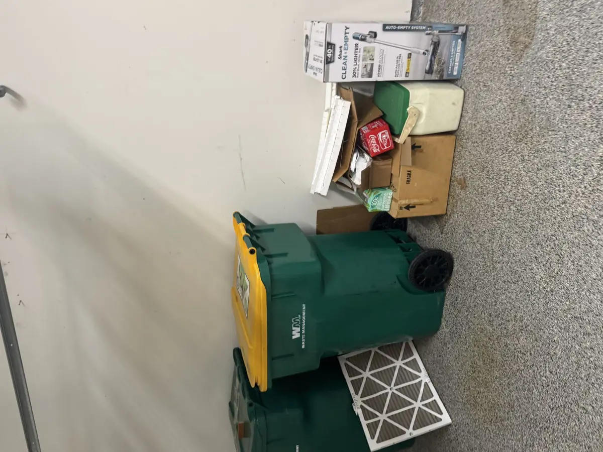 Garage corner with flattened boxes and bins during a cleanout in Alden Bridge The Woodlands TX